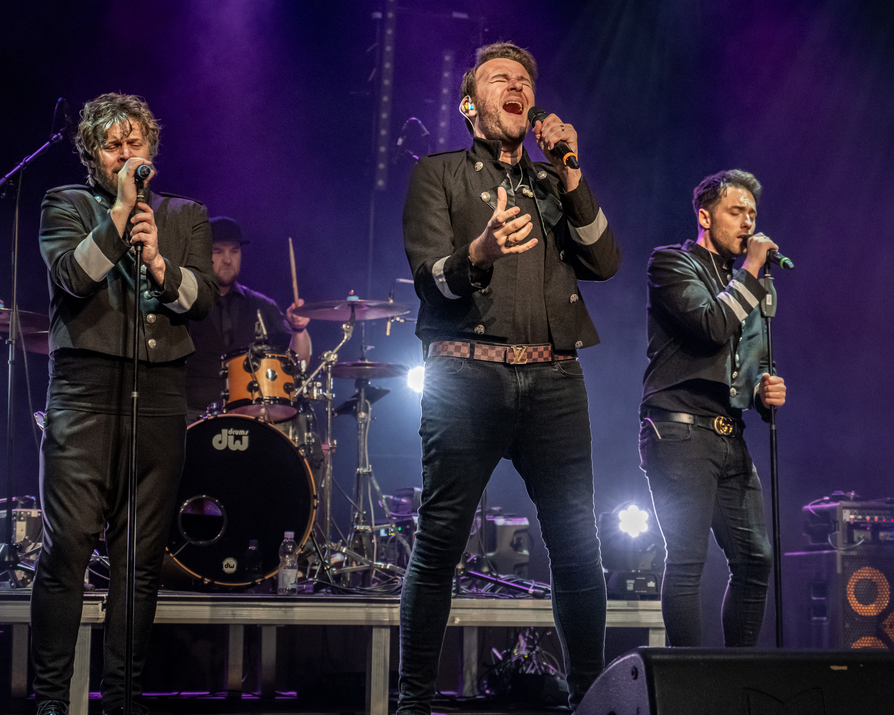 A stage with a band performing under a spotlight.